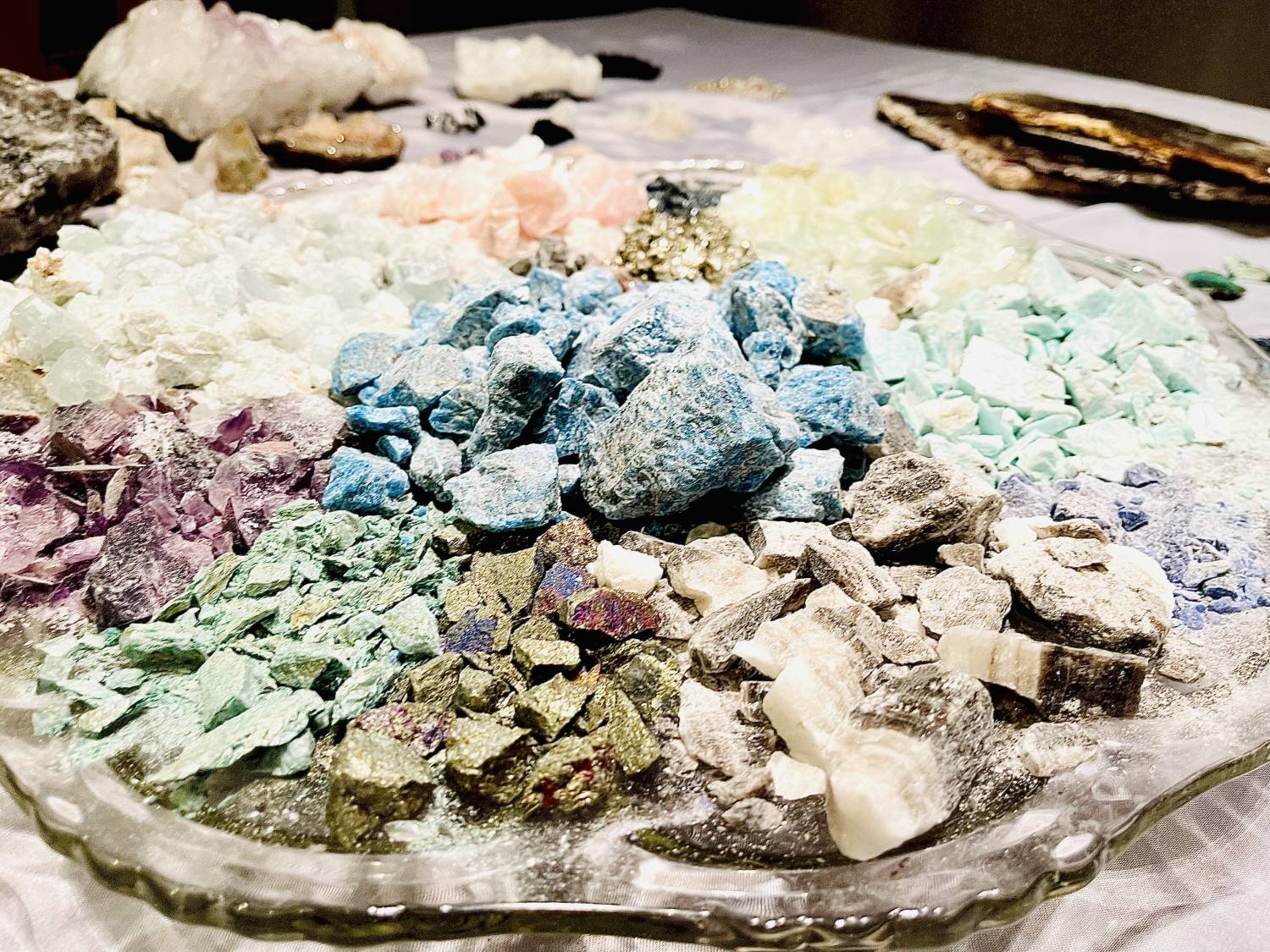 Photo of a platter of gemstones and minerals that hav ebeen smashed and organized by color.