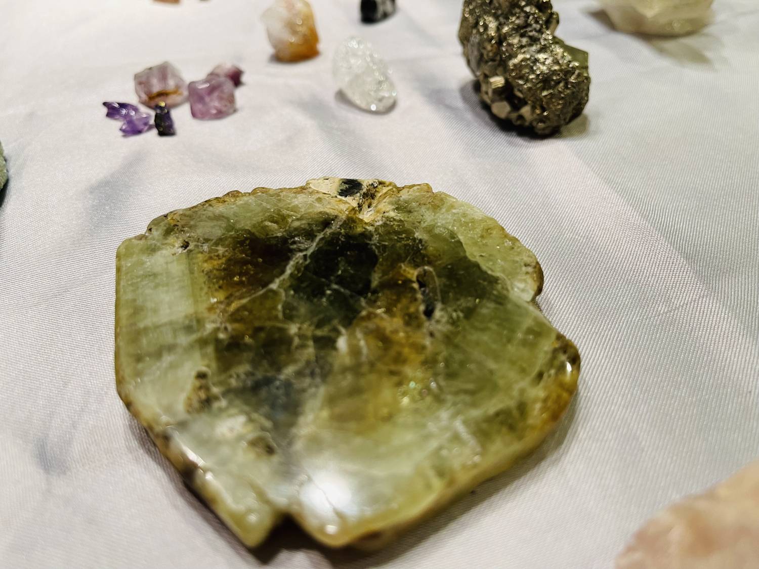 Close up of a large, dark green, flatish gemstone with a dark center.