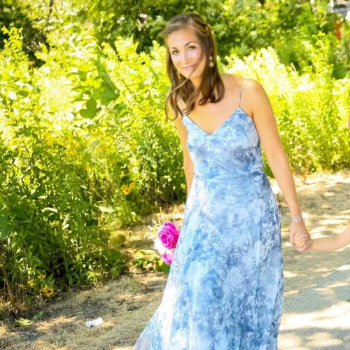 Inspiration Shelly Battista om a long blue dress in front of long green shrubbage