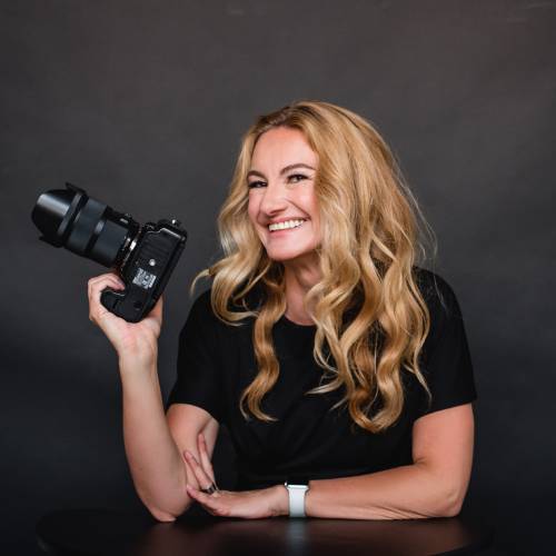 Artist Tanja Pleis in a black shirt, holding her camera